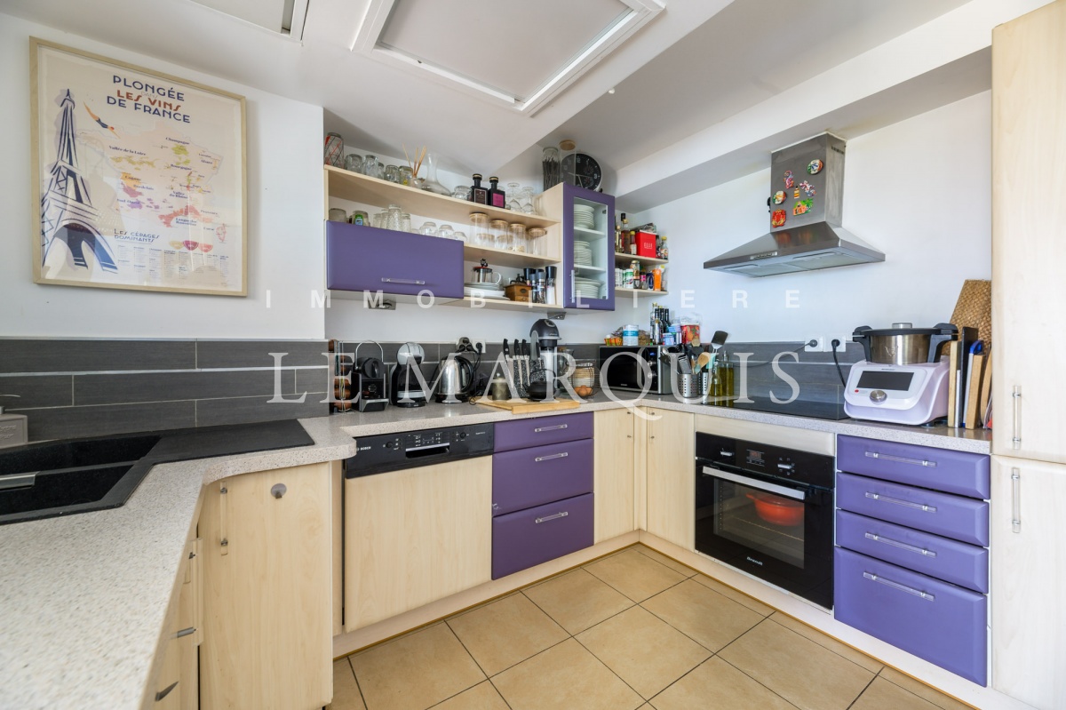 La cuisine équipée semi-ouverte est fonctionnelle et bien agencée