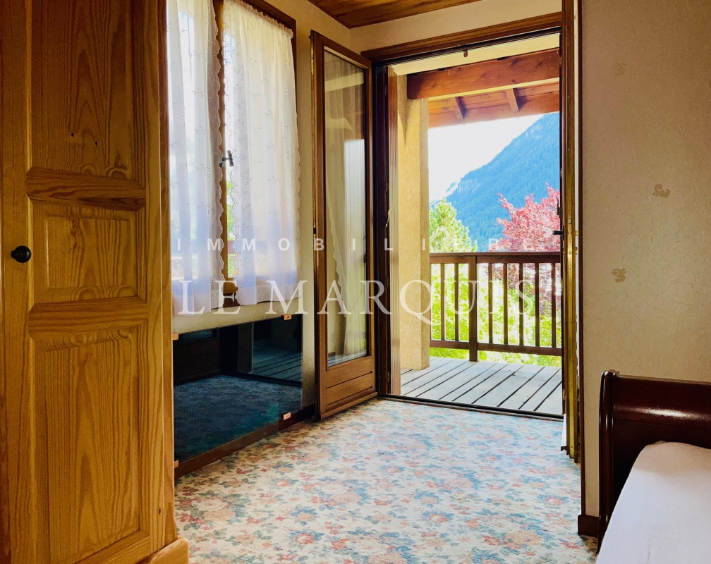 La chambre parentale au calme ouvre sur un balcon et le jardin arboré