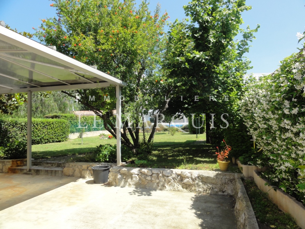 Terrasse ombragée sur le jardin avec piscine au fond